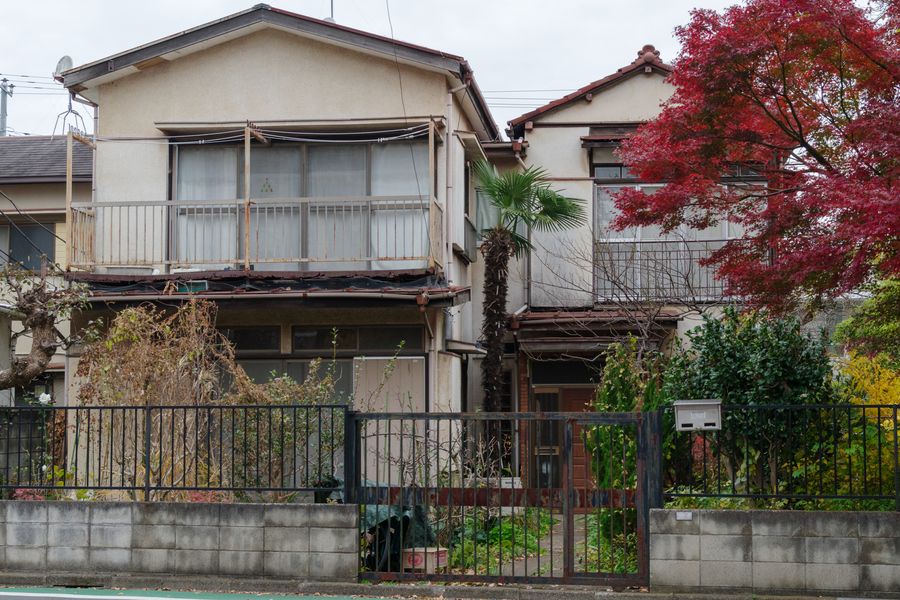 庭木が伸びて塀を越えそうになっている空き家